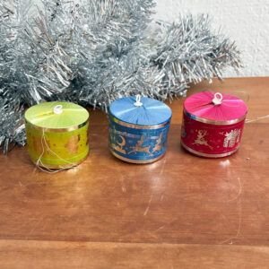 Trio of vintage 1970s green, blue, and pink silk thread drum Christmas baubles with silver tinsel background